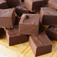 several pieces of chocolate sitting on top of a wooden cutting board