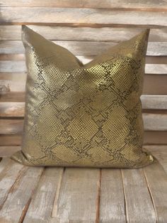 a gold pillow sitting on top of a wooden bench