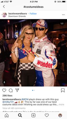 a man and woman posing for a photo in front of a crowd at a race