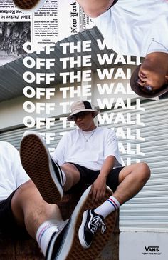 a man sitting on top of a brown chair next to a wall covered in posters