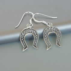 ONE PAIR of sterling silver horse shoe ear danglers. Dimensions: 12 x 17 mm Drop Length: 27 mm Weight: 1.06 gm These earrings are made of 925 hypoallergenic sterling silver. Please note this price is for ONE PAIR only. All my pieces are sent in a gift box. I can include a personal message from you if needed You are welcome to contact me at... bhavnakwintra1956@gmail.com For more beautiful pieces from my shop, please browse 👇 TOE RINGS: https://www.etsy.com/your/shops/TheSilverGame/tools/listing Silver Horseshoe Jewelry Gift, Elegant Horseshoe Earrings For Gift, Nickel-free Horseshoe Sterling Silver Jewelry, Nickel-free Silver Horseshoe Jewelry, Western Baddie, Shoe Earrings, Goodluck Charms, Country Jewelry, Silver Horse