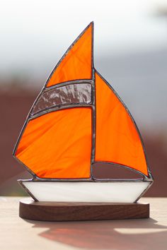 an orange and white sailboat is sitting on a table