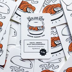 a pile of white business cards with orange and black designs on them, all in different shapes and sizes