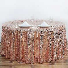 the table is covered with sequins and two white plates are on top of it