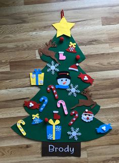 a christmas tree made out of paper with the name broddy on it and decorations