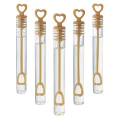 four glass tubes with gold handles and hearts on them are lined up in a row