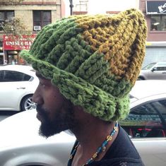 a man wearing a green and yellow knitted hat