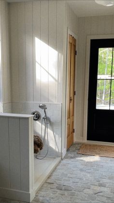 an open door leading to a bathroom with a tub and shower head in the corner