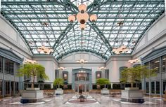 the inside of a large building with lots of windows and plants growing in it's center