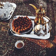 a tray that has some food on it next to a cup and teapots