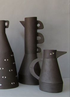 three gray vases sitting next to each other on a table