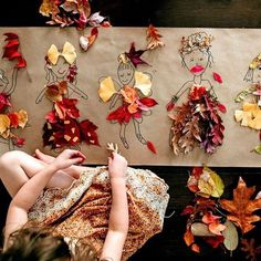 two children are playing with autumn leaves on the floor, and one child is drawing