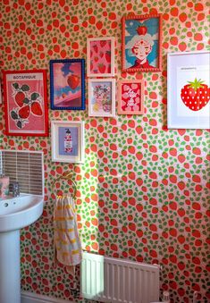 a bathroom with pictures on the wall and a sink