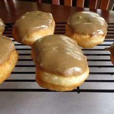 six glazed doughnuts sitting on top of a cooling rack next to each other