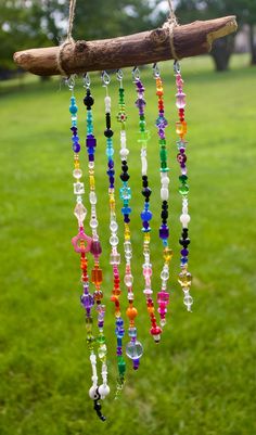 a wind chime hanging from a tree branch with beads and glass beads on it