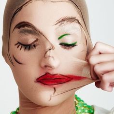 a woman with her face painted to look like marilyn monroe, wearing green and red beads