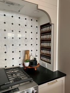 a stove top oven sitting inside of a kitchen next to a wall mounted spice rack