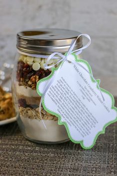 a glass jar filled with granola and nuts next to a white paper tag that says, thank you