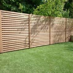 a wooden fence in the middle of a grassy area