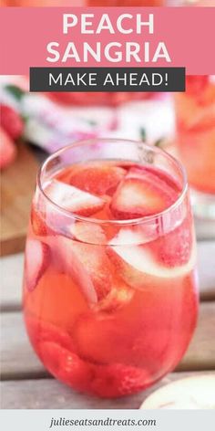 a pitcher filled with fruit and ice sitting on top of a wooden table