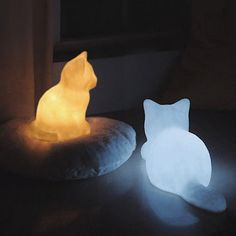 a cat shaped light sitting on top of a pillow next to a window sill