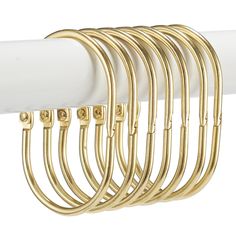 a white curtain rod with gold colored metal bars hanging from it's end, on a white background