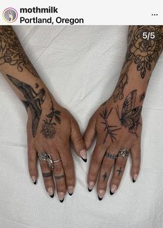 two hands with tattoos and rings on them