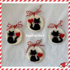 four felt ornaments with red and white stripes on the bottom one has a black cat