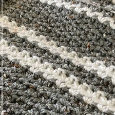 the crocheted rug is made up of two different shades of gray and white