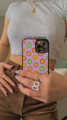 a woman holding up her phone case with flowers on it