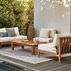 an outdoor living area with couches and tables next to a pool in the backyard