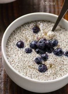 a bowl of oatmeal with blueberries in it on a wooden table