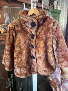 This fun, lightweight cropped jacket is made of 100 per cent acrylic faux fur in rich and shiny red and golden brown tones. It has decorative large snaps in the front and two front pockets and is fully lined. In excellent condition. The measurements, taken with the jacket lying flat, are: shoulder to shoulder, 19 inches; armpit to armpit, 22 inches; sleeves, 18 1/2 inches; overall length, 26 inches; bottom edge, 24 inches. Vintage Outerwear, Faux Fur Cropped Jacket, Brown Tones, Vintage Coat, Cropped Jacket, Golden Brown, Faux Fur Coat, Red Brown, Crop Jacket