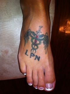 a foot with a cadus tattoo on it's left foot and the word ln written in black ink