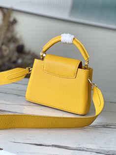 Yellow mother-of-pearl This Capucines mini handbag is made of full-grain Taurillon leather, which makes the jewel-like logo shine like malachite and injects grace into the classic design. The wide leather shoulder strap is suitable for shoulder or cross-body, and it is smart to shuttle between day and night. Dimensions: 21 x 14 x 8 cm Gold Bag With Palladium Hardware In Epsom Leather, High-end Epsom Leather Shoulder Bag For Everyday Luxury, Luxury Shoulder Bag With Top Handle, Everyday Luxury Epsom Leather Shoulder Bag With Detachable Strap, Gold Epsom Leather Bag With Branded Hardware, Luxury Epsom Leather Shoulder Bag For Evening, Gold Epsom Leather Bag For Everyday Luxury, High-end Gold Epsom Leather Bag, Luxury Bags With Adjustable Strap And Round Handle