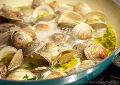 clams are being cooked in a pan on the stove