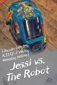 a blue helmet sitting on top of a wooden floor next to a sign that reads, lincoln electric k322 - 3 viking welding welding welding helmet