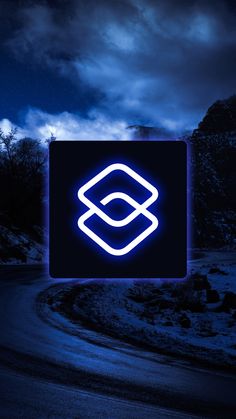 a blue neon sign sitting on the side of a road in front of a dark sky