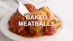 a white plate topped with meatballs covered in marinara sauce next to a fork