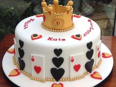 a birthday cake decorated with playing cards and a crown