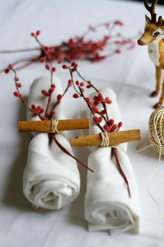 two small deer figurines sitting on top of a table next to twine spools