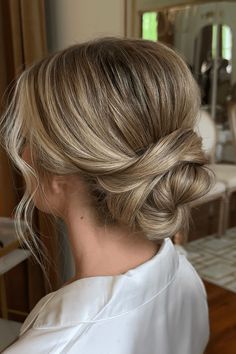 This loosely tousled low bun radiates a timeless flair with its soft, textured waves that naturally frame the face. Ideal for a romantic wedding, the hairstyle blends an effortless undone look with a charming appeal, creating a beautiful contrast that complements any bridal gown. Delicate loose strands add a - Click to see more of Romantic and Undone: 30 Stunning Low Messy Bun Looks for the Effortless Bride and follow us for more hairstyle ideas. // Photo Credit: Instagram @styledxpaige Low Bun Bridesmaid Hair Front View, Soft Bun Wedding Hair, Soft Bridal Bun, Bridesmaids Low Bun, Elegant Bridal Updo With Veil, Loose Low Bun Wedding Hair, Low Wedding Bun, Messy Bun Wedding Hairstyles, Low Bun Updo Wedding