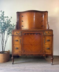 an old wooden dresser sitting next to a potted plant