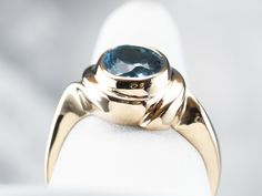 This vintage gold mounting is simple with decorative, sweeping shoulders on the sides and a secure bezel setting. We've set this piece with a modern, large oval blue topaz. The color of this stone is deeper, a rich, electric color. This would make a lovely cocktail ring, and is also a sturdy enough stone to wear every day! Metal: 14K Yellow Gold Gem: Blue Topaz 3.09 Carats Gem Measurements: 9.3 x 6.8 mm, Oval Ring Size: 9 Marks: "14K" Stamped on the inside band Gold Topaz Ring, Right Hand Ring, Gold Topaz, Ring Bezel, Bypass Ring, Cameo Ring, Right Hand Rings, Hand Ring, Oval Ring