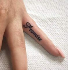 a person's hand with a small tattoo on it that says, momie