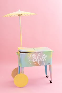 a toy ice cream cart with an umbrella on it's top and the word toshilla written in cursive writing