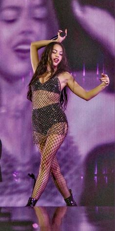 a woman is dancing on stage in fishnet stockings