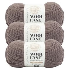 three skeins of wool ease yarn in grey, with white labels on them