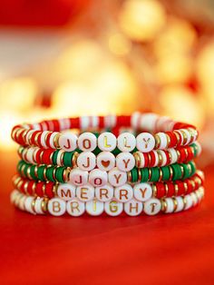 three bracelets with words written on them sitting on a table next to a lit candle