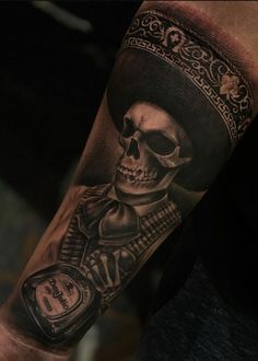 a man's arm with a skull and clock tattoo on the left side of his arm